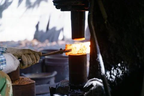 The blacksmith is forging very hot iron to make various tools. Stock Photos
