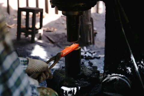The blacksmith is forging very hot iron to make various tools. Stock Photos