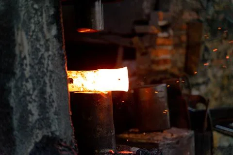 The blacksmith is forging very hot iron to make various tools. Stock Photos