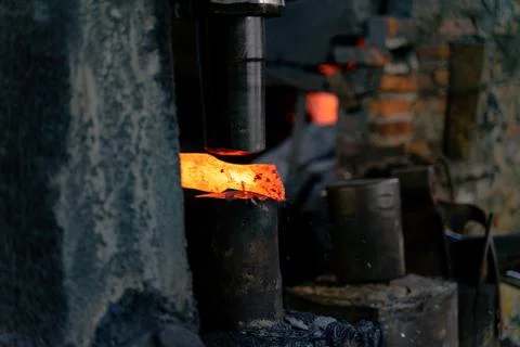 The blacksmith is forging very hot iron to make various tools. Stock Photos