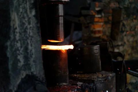 The blacksmith is forging very hot iron to make various tools. Stock Photos