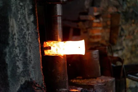 The blacksmith is forging very hot iron to make various tools. Stock Photos