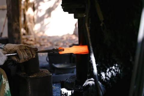 The blacksmith is forging very hot iron to make various tools. Stock Photos