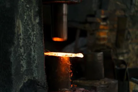 The blacksmith is forging very hot iron to make various tools. Stock Photos