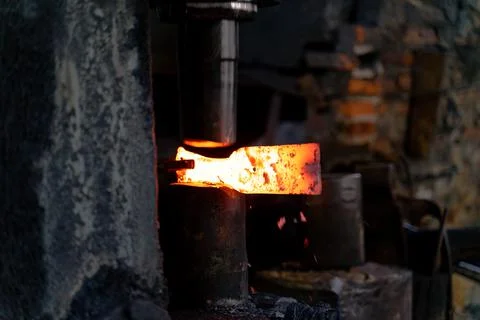The blacksmith is forging very hot iron to make various tools. Stock Photos