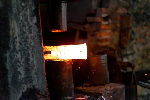 The blacksmith is forging very hot iron to make various tools. Stock Photos