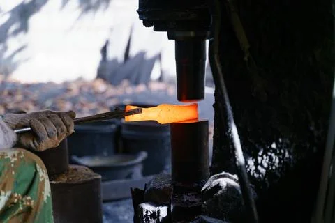 The blacksmith is forging very hot iron to make various tools. Stock Photos