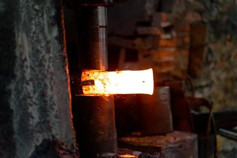 The blacksmith is forging very hot iron to make various tools. Stock Photos