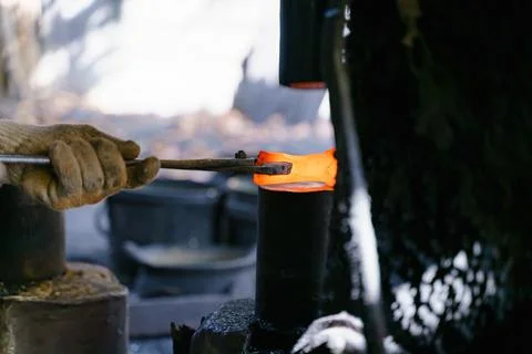 The blacksmith is forging very hot iron to make various tools. Stock Photos