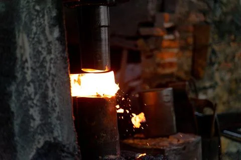 The blacksmith is forging very hot iron to make various tools. Stock Photos