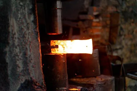 The blacksmith is forging very hot iron to make various tools. Stock Photos