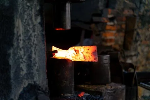 The blacksmith is forging very hot iron to make various tools. Stock Photos