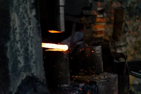 The blacksmith is forging very hot iron to make various tools. Stock Photos