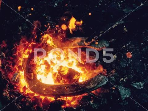 Blacksmith form horse shoe from semiproduct Stock Photos