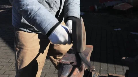 A blacksmith forming a detail from a strip of hot metal Stock Footage 196105448