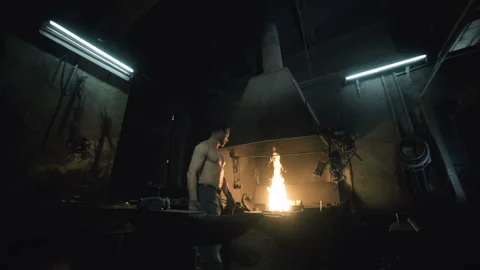 The blacksmith gets a hot metal bar out of the fire to get started Видео 109600907