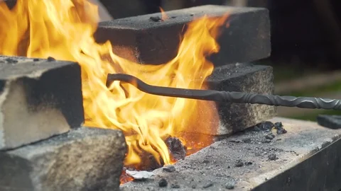Blacksmith gets hot metal out of the fire 動画素材 112830749