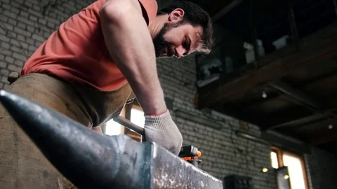 Blacksmith with hammer in forge creating steel knife Stock Footage 75275241