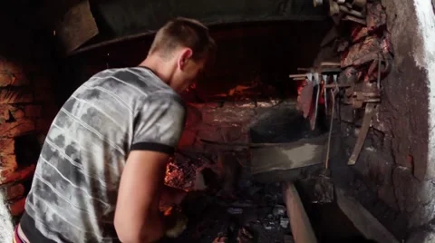 Blacksmith hammer smashes coal to fire a small oven Stock Footage 46421445