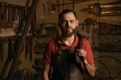 Blacksmith with hammer in workshop closeup portrait Stock Photos