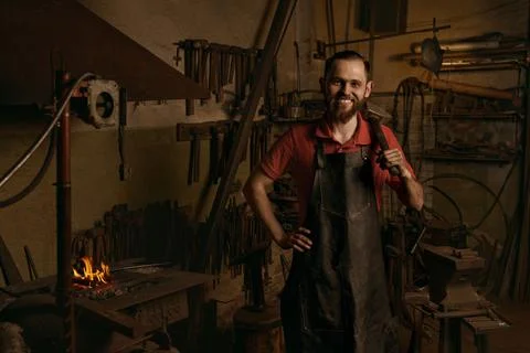 Blacksmith with hammer in workshop portrait smiling Stock Photos