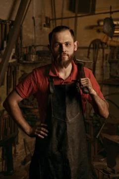 Blacksmith with hammer in workshop serious portrait Stock Photos