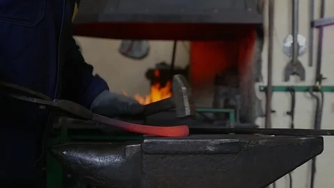 Blacksmith hammering the end of an Iron bar into a hook, slow motion Stock Footage 78902629
