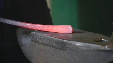 Blacksmith hammering the end of an Iron bar into a hook Stock Footage 78903424