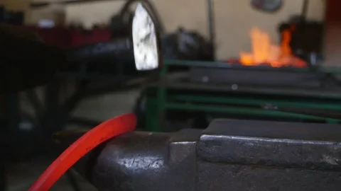 Blacksmith hammering the end of an Iron bar into a hook Stock Footage 78903746