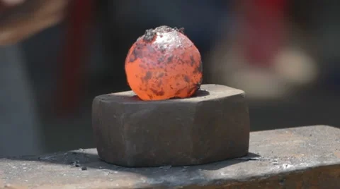 Blacksmith hammering hot round metal to shape it Stock Footage 7769228