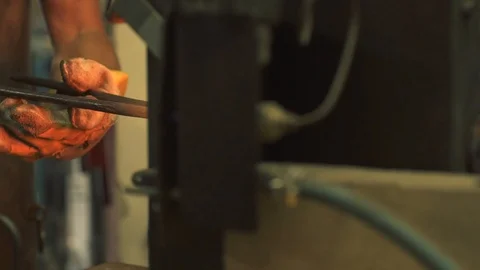 Blacksmith hammering a metal object with a power hammer Stock Footage 128597090