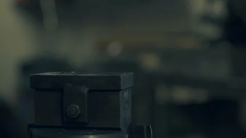 Blacksmith hammering a metal object with a power hammer Stock Footage 128597120