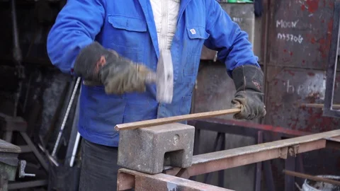 Blacksmith hammering on a metal profile Stock Footage 101948294