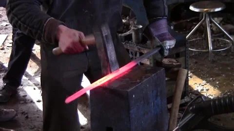 Blacksmith hammering a sword Stockbeeldmateriaal 48669617