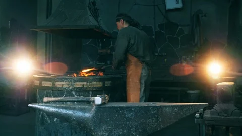 A blacksmith hammers a hot knife on anvil. Stock Footage 114553038