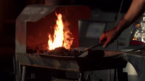 Blacksmith hand forging hot metal on an anvil in forge with spark fireworks Stock Footage 256264680