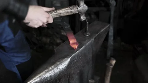 Blacksmith hands hammering hot glowing steel on anvil closeup traditional metal Stock Footage 321401928