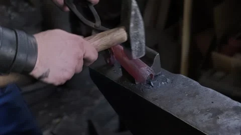 Blacksmith hands hammering hot glowing steel on anvil closeup traditional metal Stock-Footage 321422493