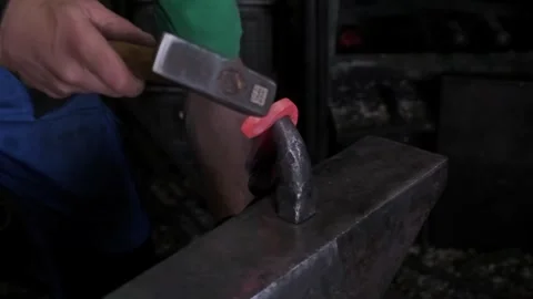 Blacksmith hands hammering hot glowing steel on anvil closeup traditional metal Video stock 321751122