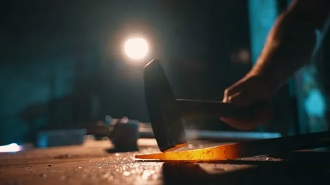 The blacksmith hands hit the hot metal with a hammer. Stock Footage 224364243