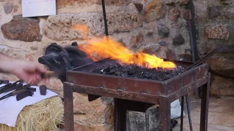 Blacksmith heating fire to work in a traditional way Stock Footage 245223319