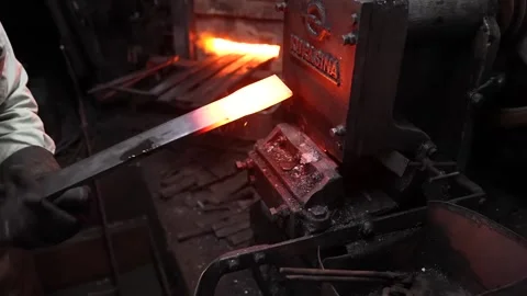 Blacksmith Heating a Glowing Steel Blade in a Forge Furnace Stock Footage 340009289