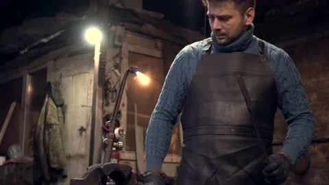 Blacksmith heating metal at flame in his workshop Stock Footage 132652884