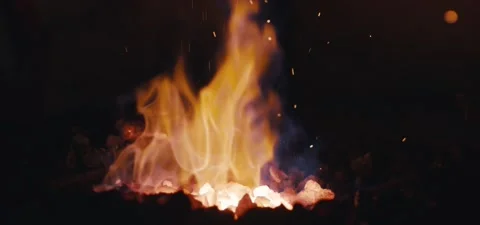 Blacksmith heating a piece of iron forging in workshop at night Stock Footage 130501487
