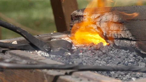 Blacksmith heating steel in charcoal forge Video stock 138250460