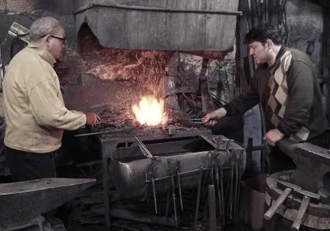 Blacksmith heats iron in the fire Stock-Fotos