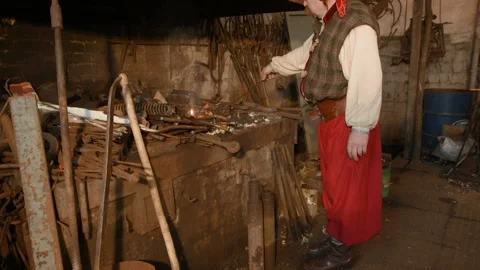 Blacksmith heats item before forgingin smithy Stock-Footage 103749613