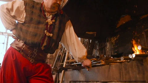 Blacksmith heats item before forgingin smithy Stock-Footage 116997005