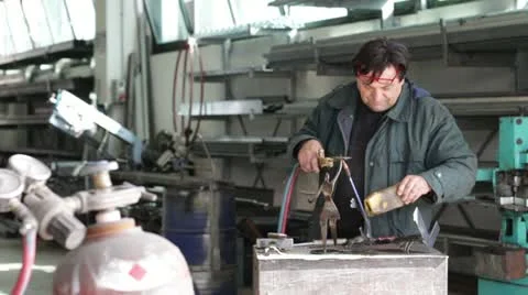 Blacksmith heats piece of metal for forging a candle holder - dolly 스톡 동영상 22016843