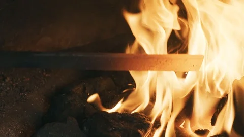 Blacksmith heets iron plate in an open fire furnace 04 (120fps) (color graded) Stock Footage 126968291